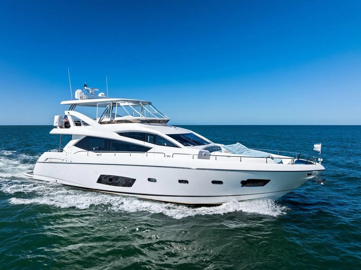 A sleek and modern yacht cruises through the open sea under a clear blue sky. aboard IT'S ENOUGH Yacht for Sale