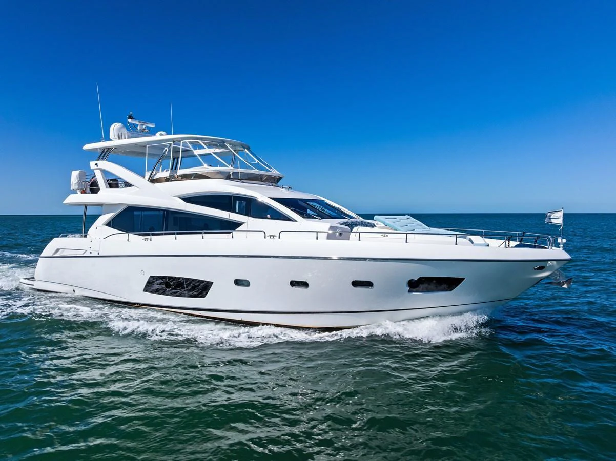 A sleek and modern yacht cruises on the open water under a clear blue sky. aboard IT'S ENOUGH Yacht for Sale