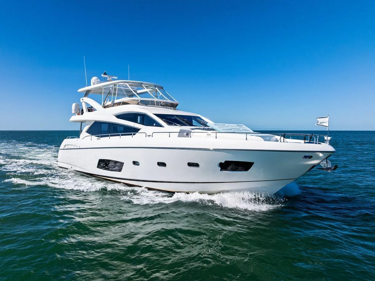 A sleek white yacht cruises smoothly on the open water under a clear blue sky. aboard IT'S ENOUGH Yacht for Sale