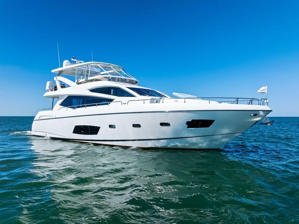 A sleek white yacht cruises smoothly on the open water under a clear blue sky. aboard IT'S ENOUGH Yacht for Sale