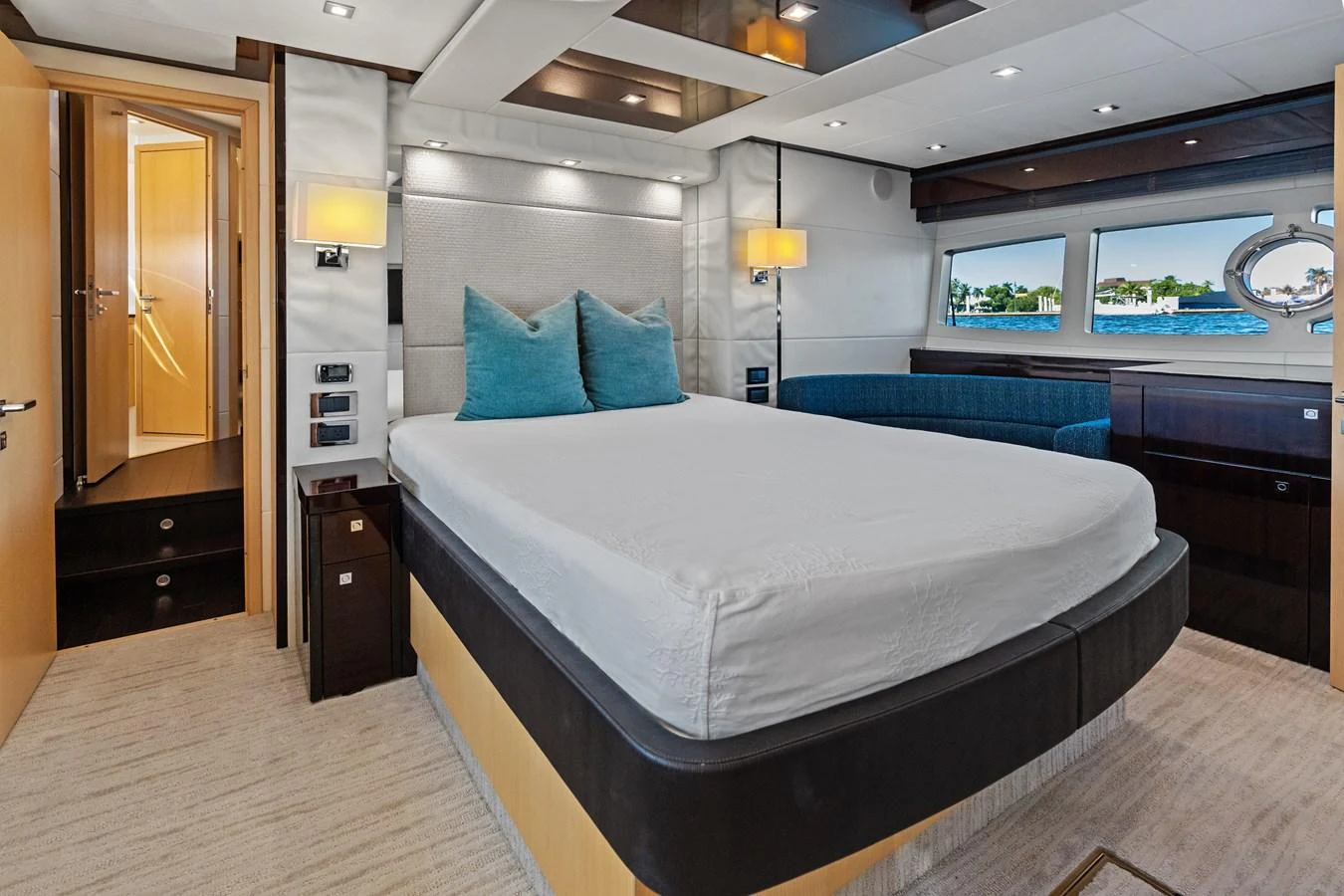 The stateroom features a luxurious bed with plush pillows, ambient lighting, and a scenic view through the windows. aboard IT'S ENOUGH Yacht for Sale