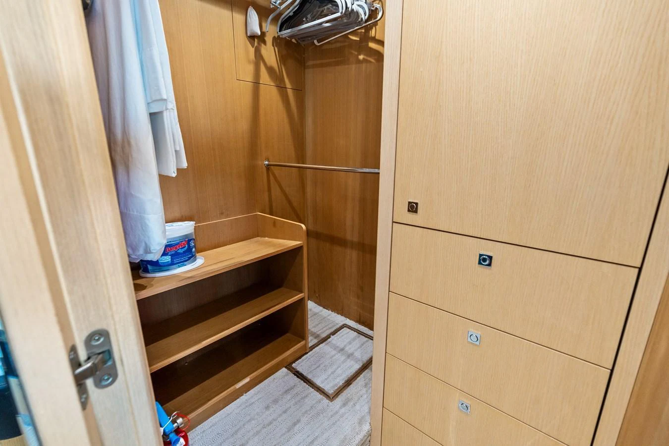 A well-organized yacht closet with ample storage space and wooden finishes. aboard IT'S ENOUGH Yacht for Sale