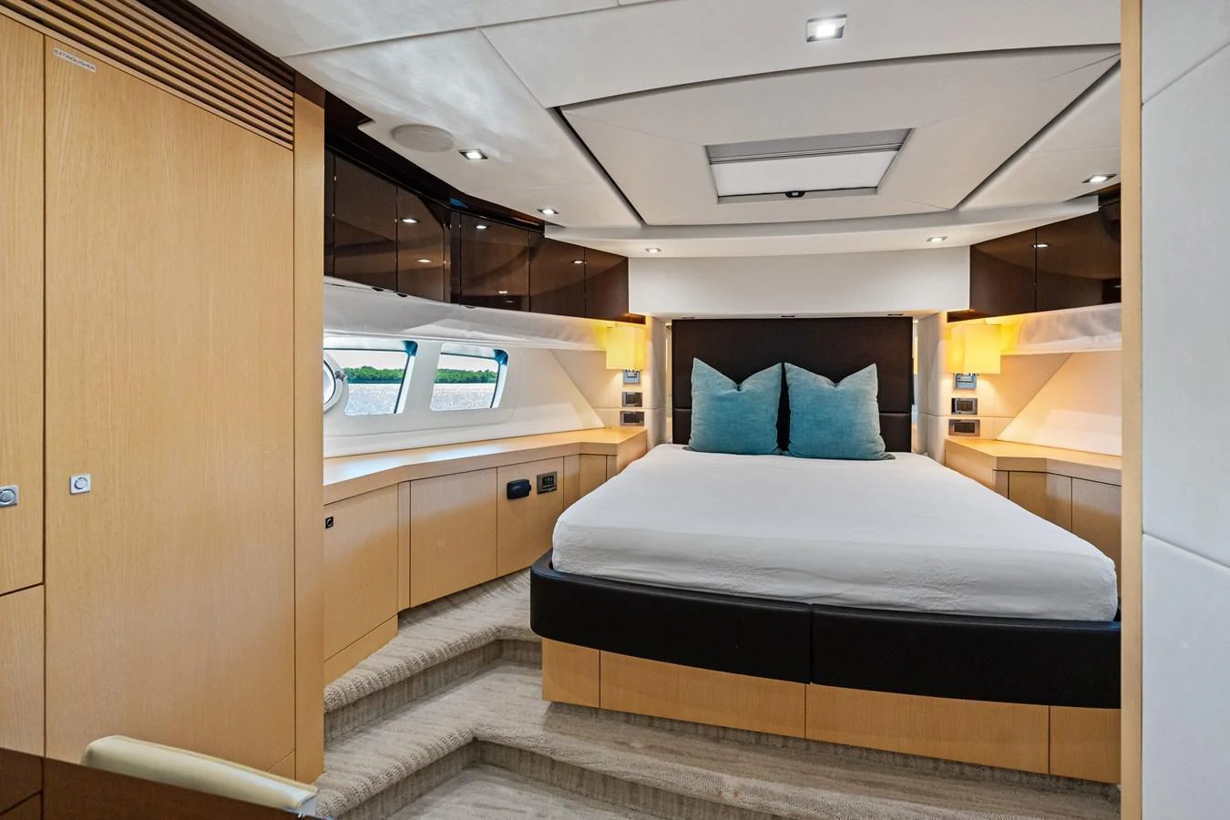 The master stateroom features a luxurious bed with ample natural light and elegant wood finishes. aboard IT'S ENOUGH Yacht for Sale