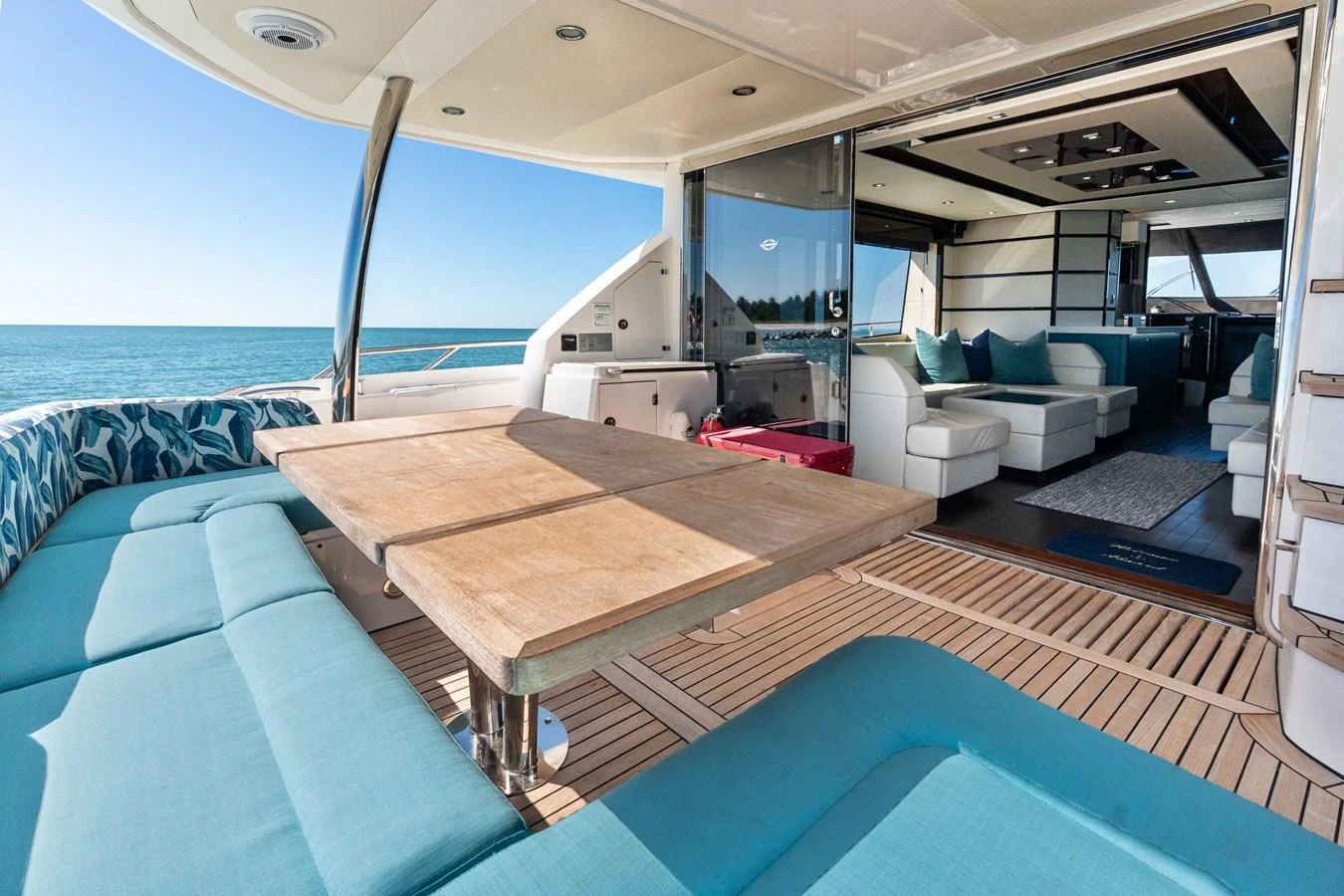 The aft deck offers a seamless transition from outdoor lounging to indoor comfort with plush seating and a dining area. aboard IT'S ENOUGH Yacht for Sale