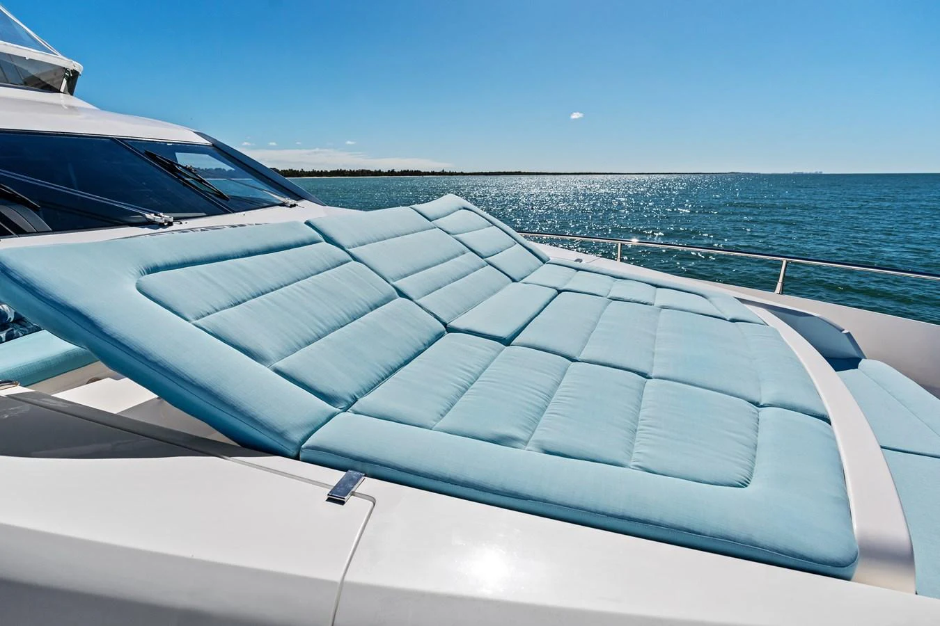The yacht features a spacious sundeck with comfortable blue cushions, perfect for relaxation while enjoying the sea view. aboard IT'S ENOUGH Yacht for Sale