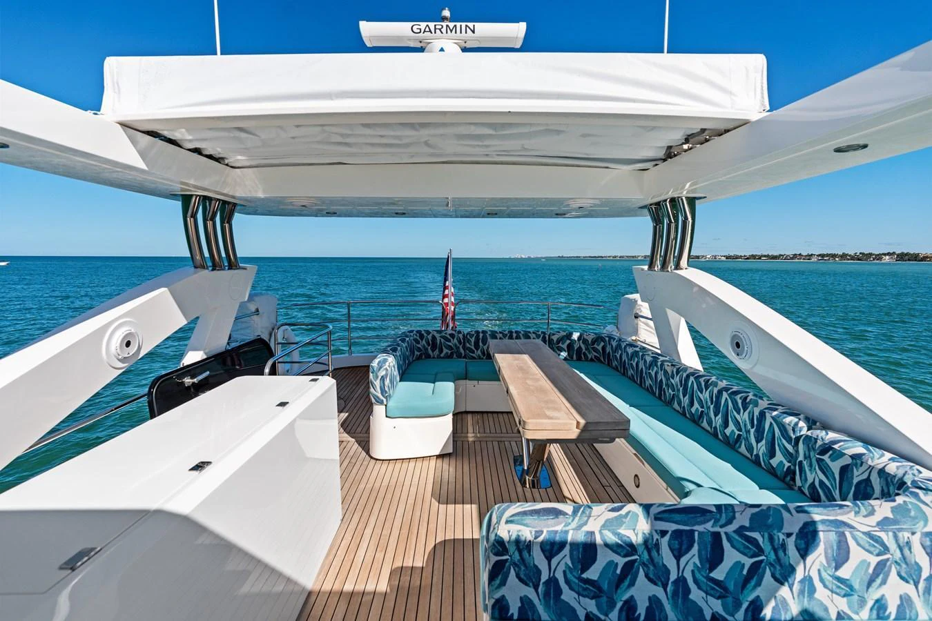 The flybridge offers a spacious seating area with a table, perfect for outdoor relaxation and dining. aboard IT'S ENOUGH Yacht for Sale