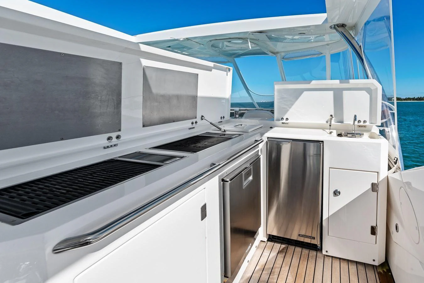 The yacht features a sleek and modern outdoor galley with stainless steel appliances and ample counter space. aboard IT'S ENOUGH Yacht for Sale