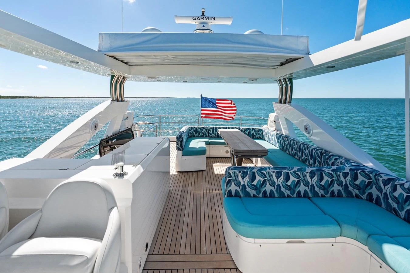 The aft deck offers a spacious and inviting area with comfortable seating and a dining table, perfect for enjoying the open sea. aboard IT'S ENOUGH Yacht for Sale