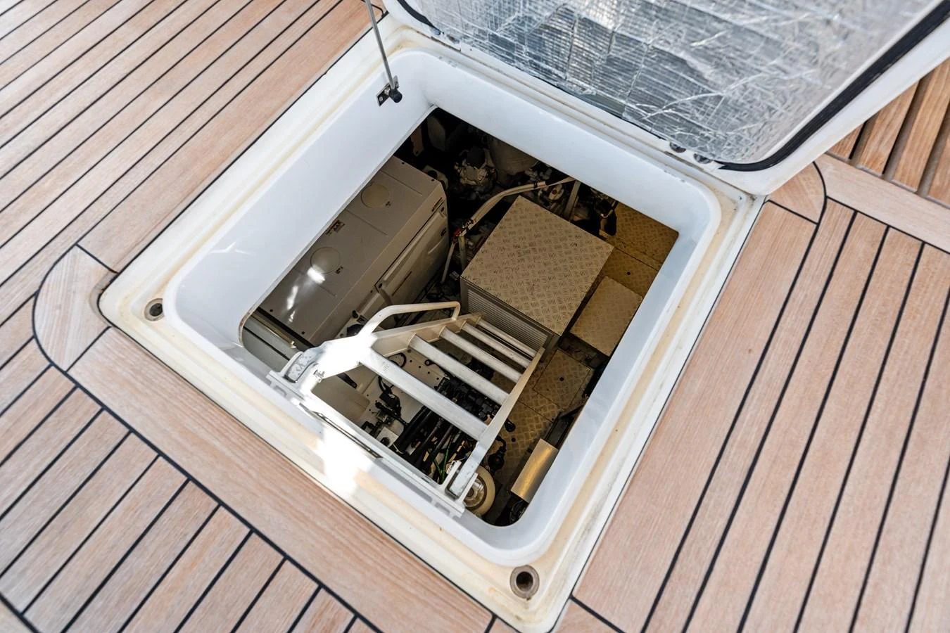 This image showcases the engine room access hatch on the yacht's deck, revealing the machinery below. aboard IT'S ENOUGH Yacht for Sale
