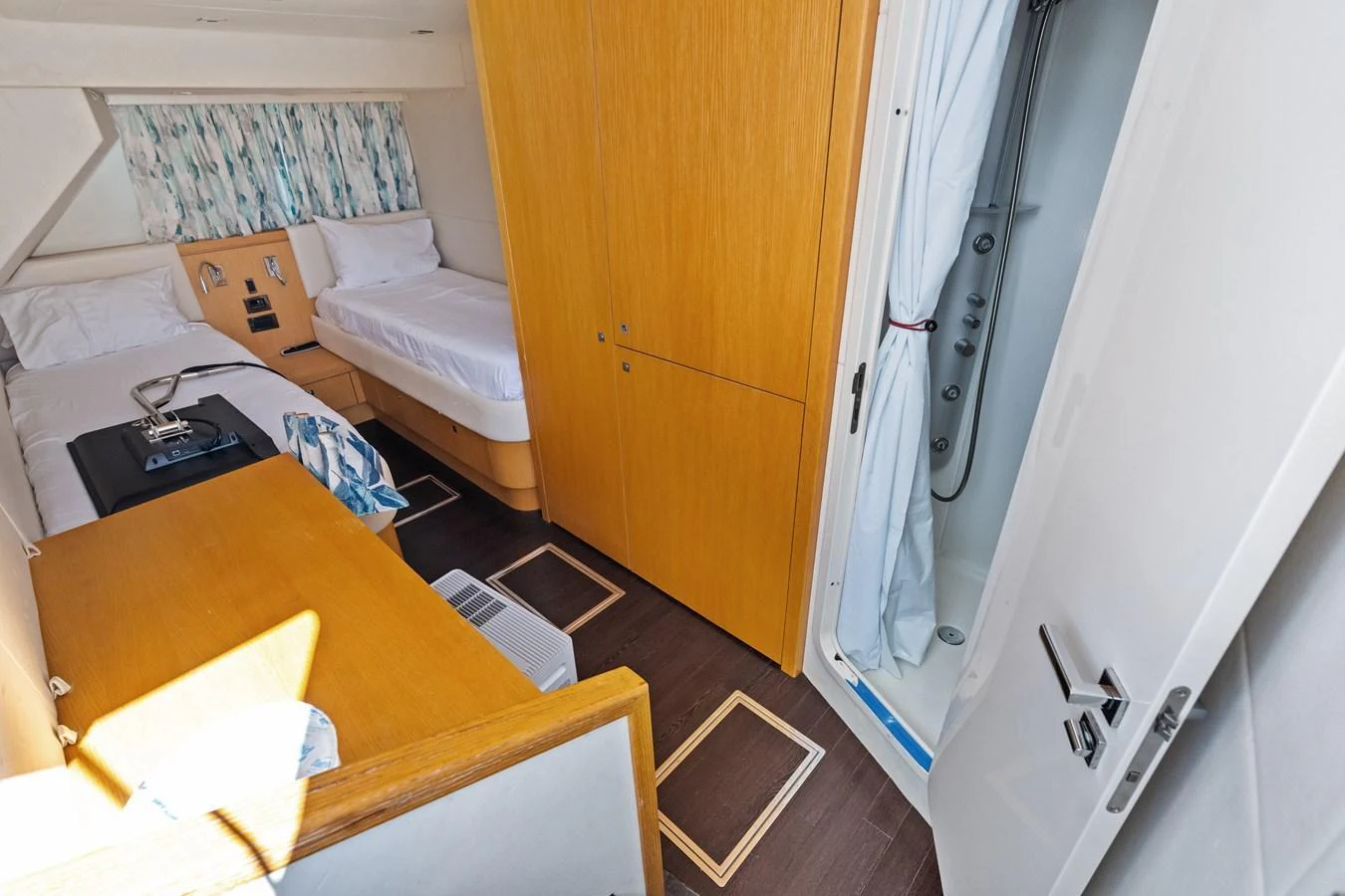 The guest cabin features twin beds, a wooden wardrobe, and an en-suite bathroom. aboard IT'S ENOUGH Yacht for Sale