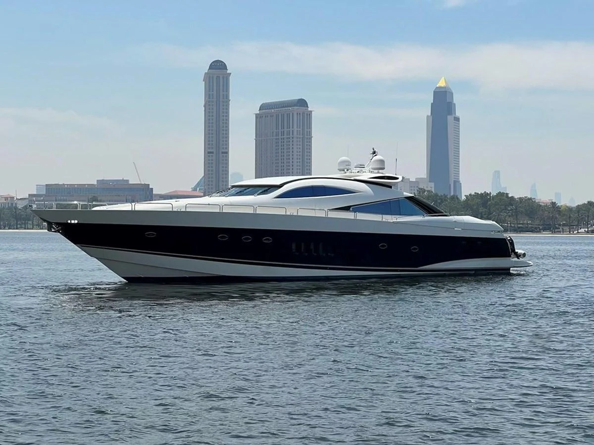 A sleek and modern yacht cruises gracefully on calm waters with a city skyline in the background. aboard TIMELESS C Yacht for Sale