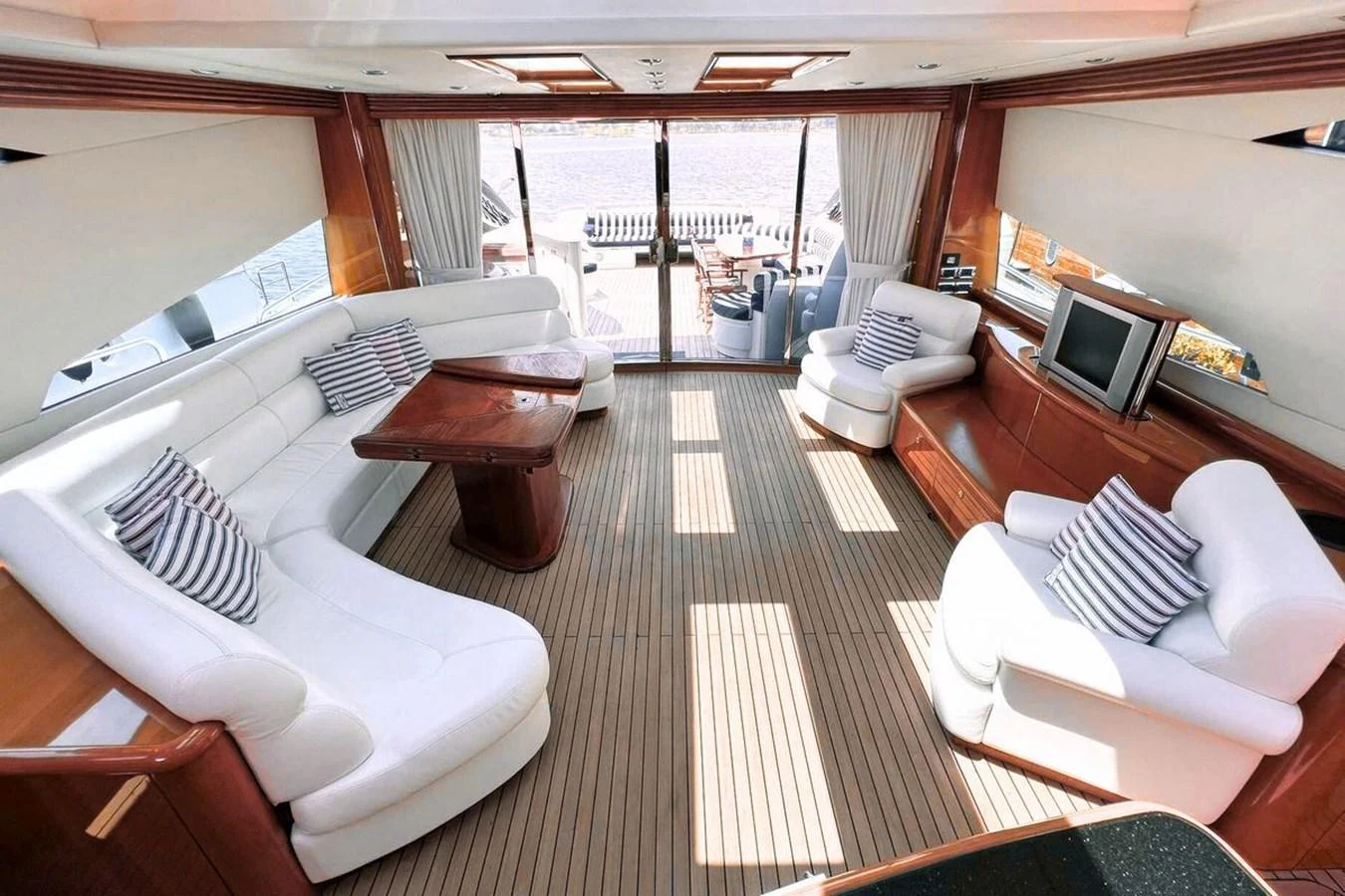 The yacht's salon features plush white seating, wooden accents, and ample natural light. aboard TIMELESS C Yacht for Sale