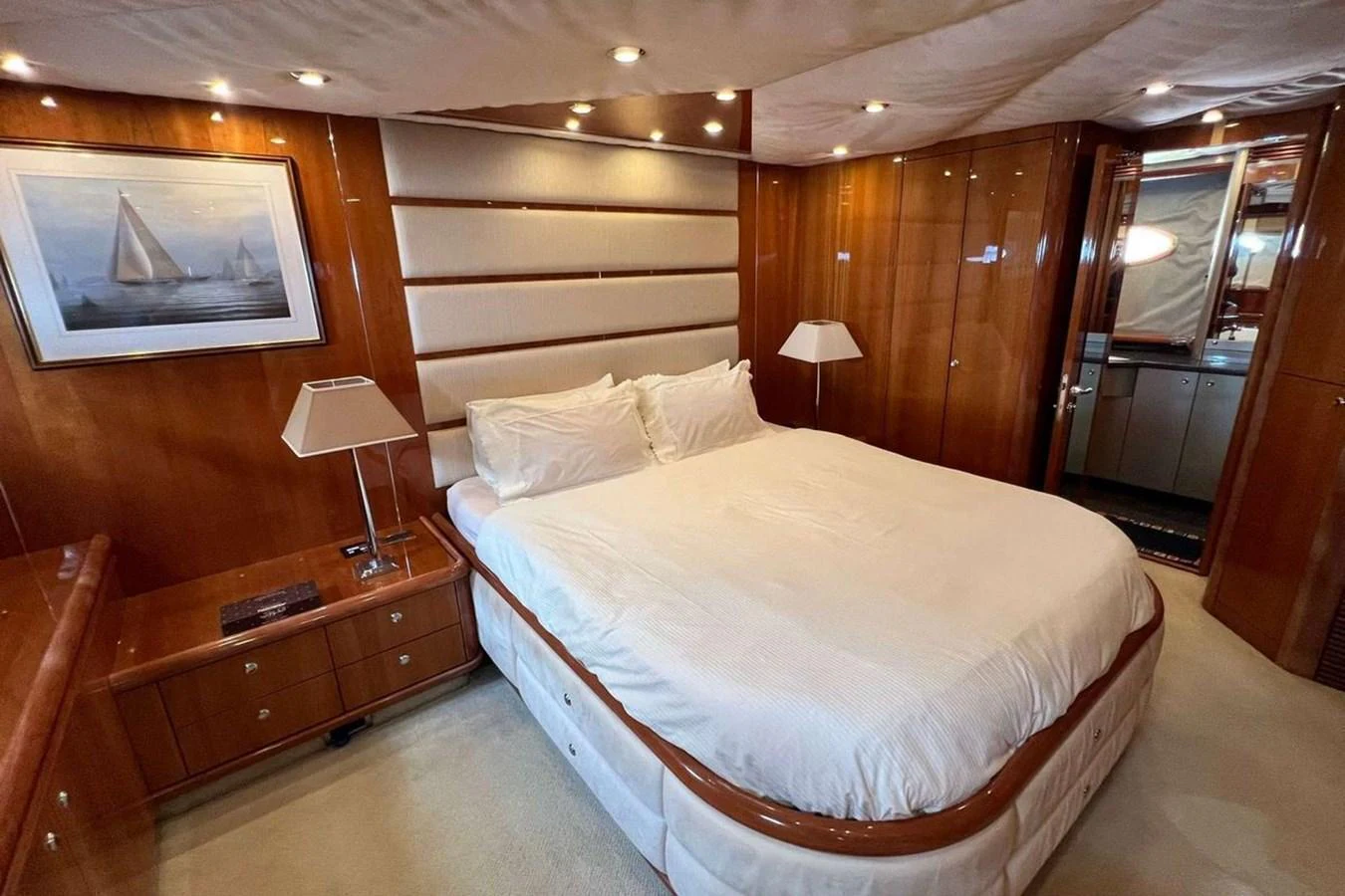 The master stateroom features a luxurious bed with elegant wood paneling and soft lighting. aboard TIMELESS C Yacht for Sale