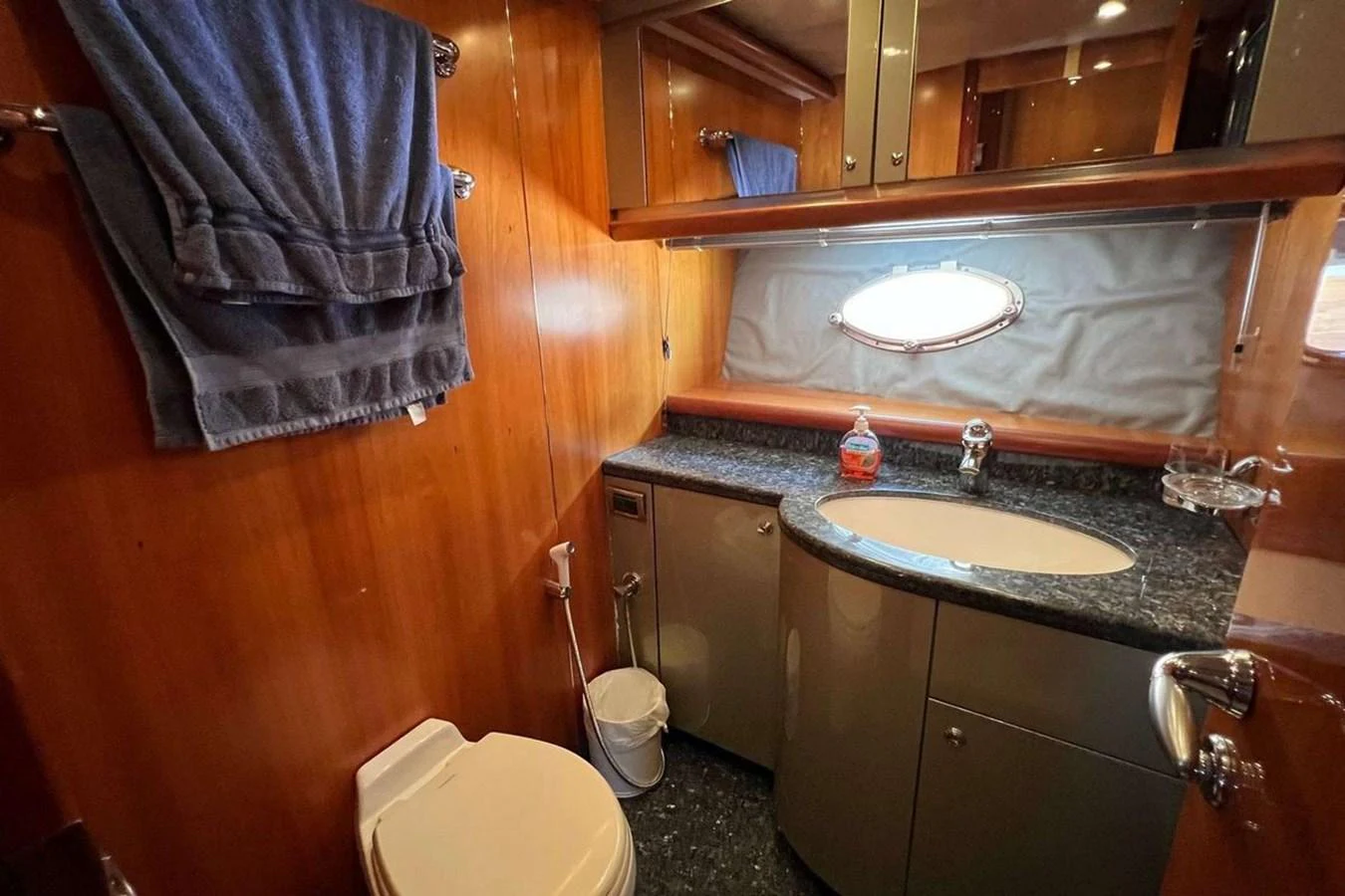 The yacht's bathroom features elegant wood paneling and a sleek countertop with a modern sink. aboard TIMELESS C Yacht for Sale