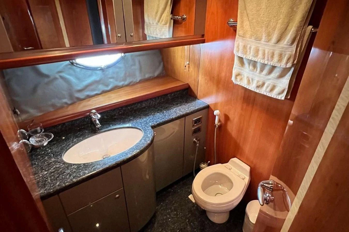 A well-appointed yacht bathroom featuring a sleek sink, toilet, and ample storage. aboard TIMELESS C Yacht for Sale