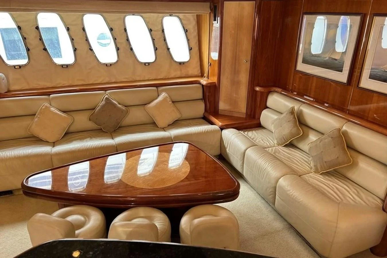 The salon features plush leather seating, a polished wooden table, and large windows for natural light. aboard TIMELESS C Yacht for Sale