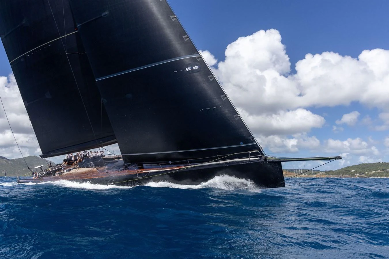 A sleek sailing yacht glides through the vibrant blue waters under a clear sky. aboard BULLITT Yacht for Sale