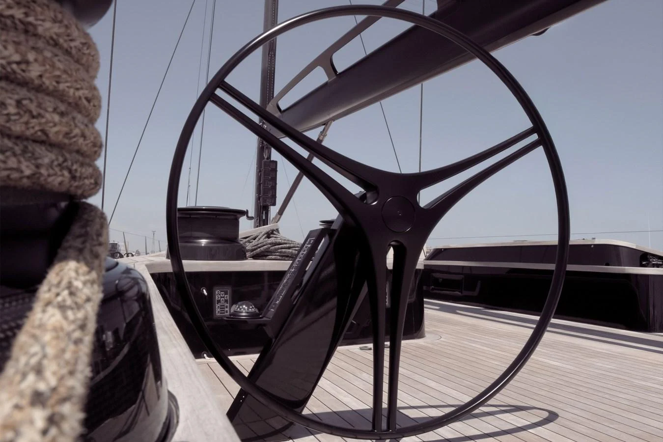 A sleek and modern helm station with a large steering wheel on the deck. aboard BULLITT Yacht for Sale