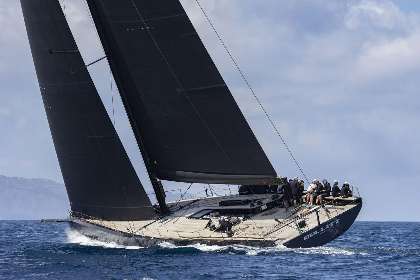 A sleek sailing yacht glides swiftly over the water with its sails fully extended. aboard BULLITT Yacht for Sale
