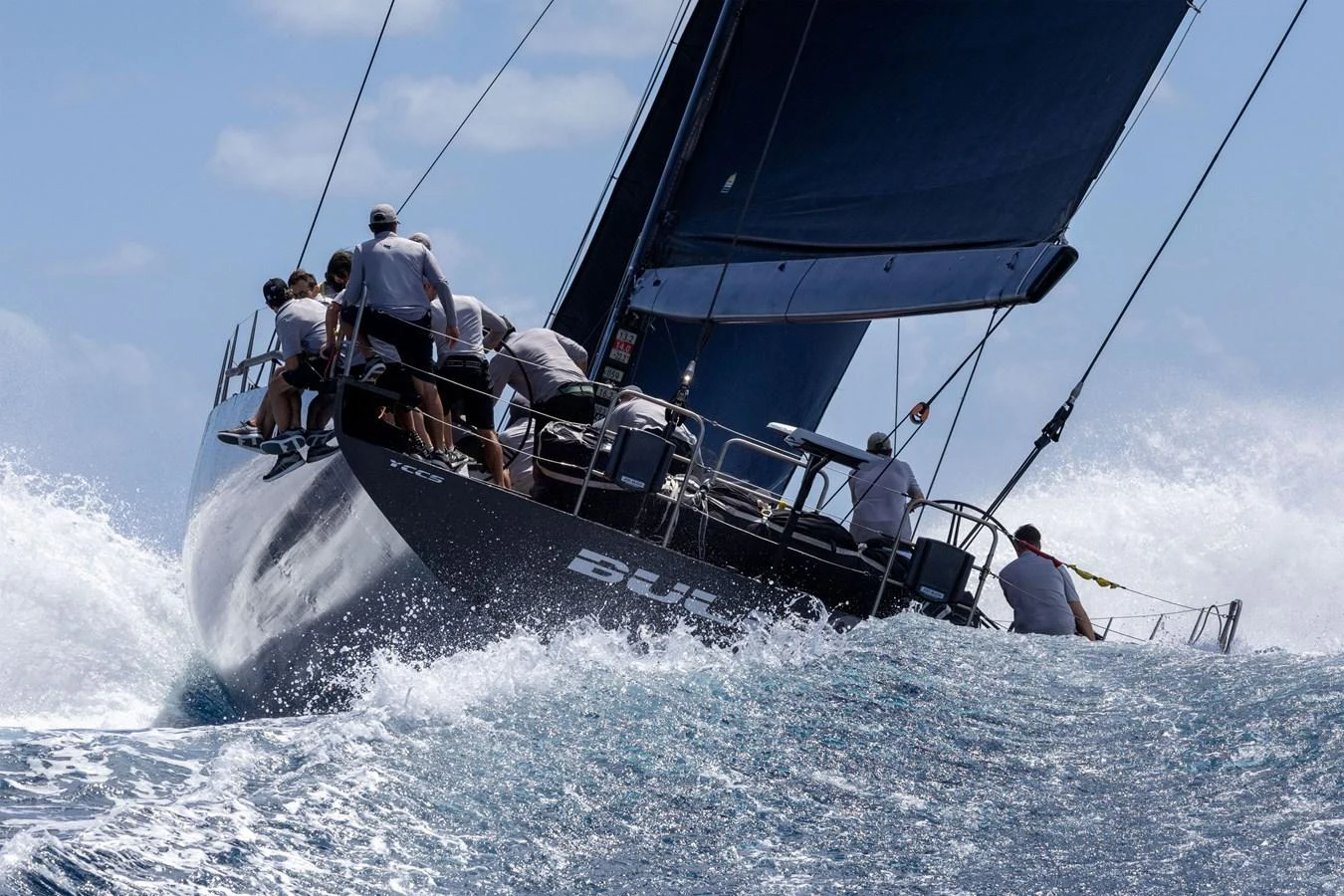 A sleek sailing yacht cuts through the waves with its crew in action. aboard BULLITT Yacht for Sale