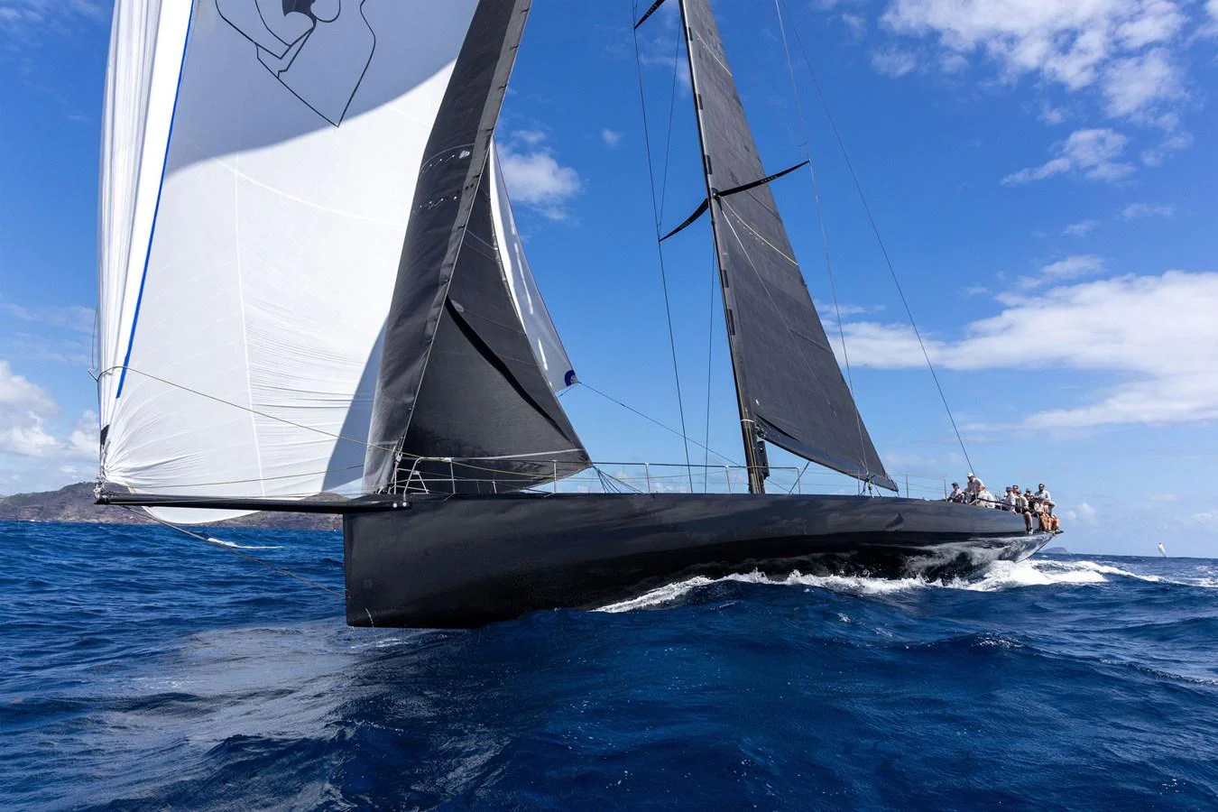 A sleek sailing yacht glides through the deep blue ocean under full sail. aboard BULLITT Yacht for Sale