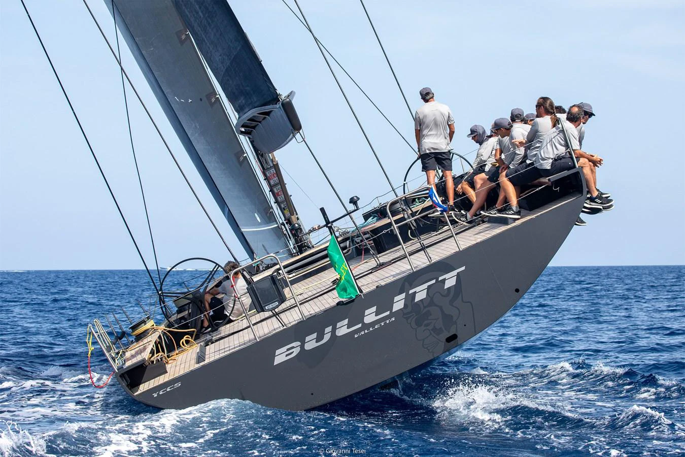A sleek sailing yacht with a crew on deck, cutting through the waves. aboard BULLITT Yacht for Sale