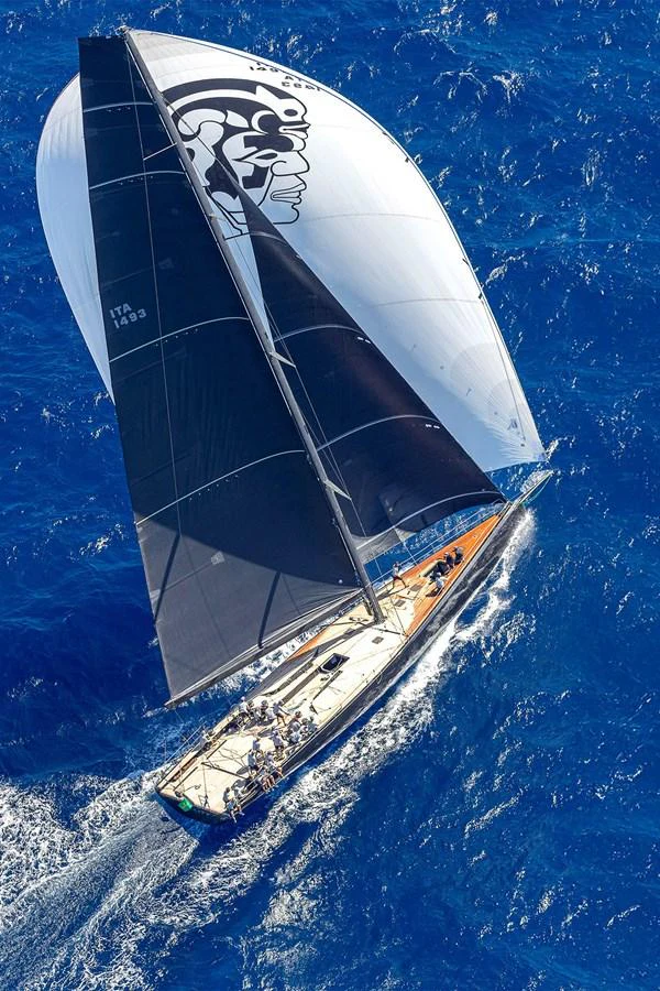 An elegant sailing yacht glides through the vibrant blue ocean, showcasing its sleek design and impressive sails. aboard BULLITT Yacht for Sale