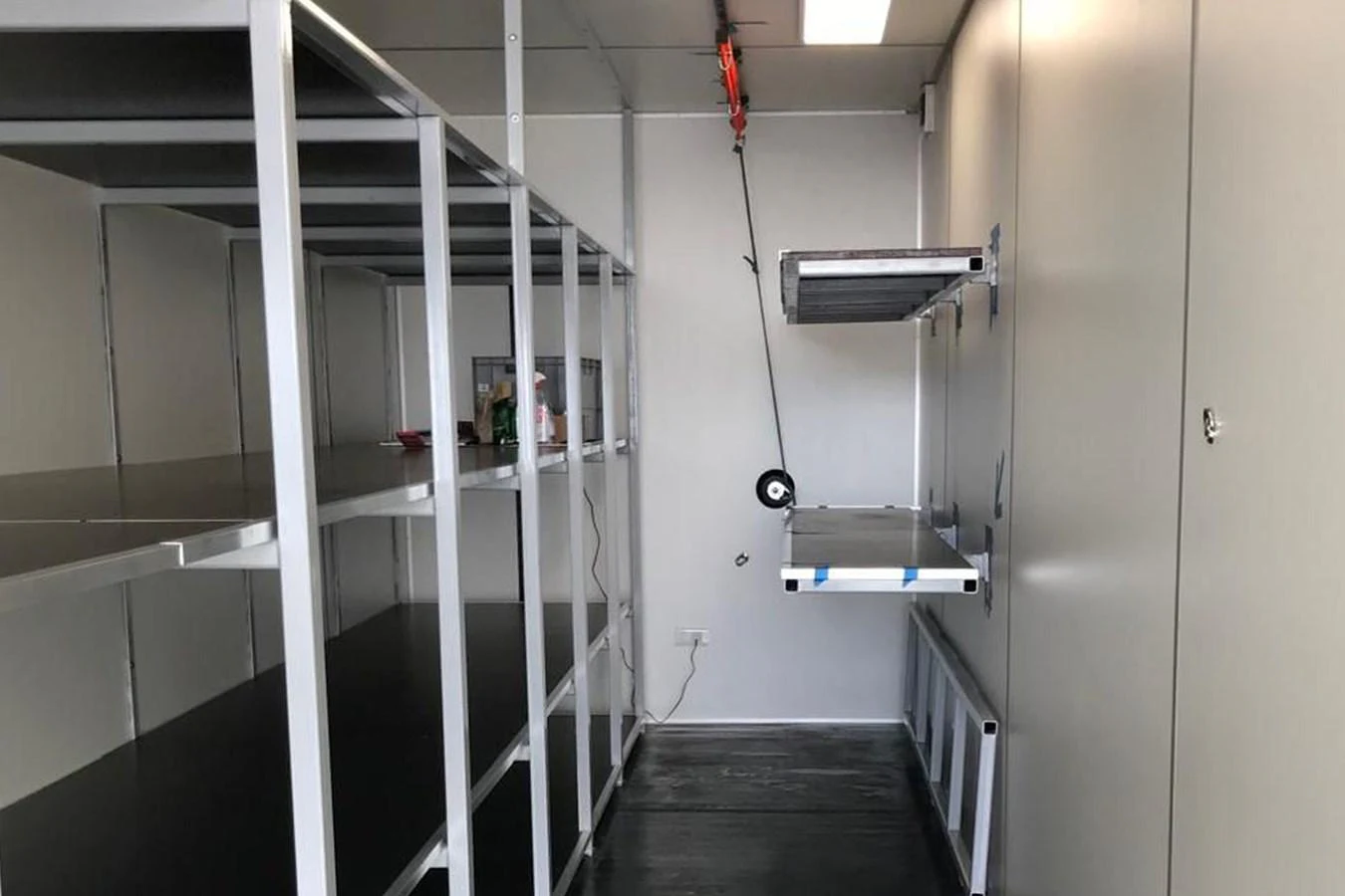 This image shows a storage area within the yacht, featuring metal shelving and a workbench. aboard BULLITT Yacht for Sale