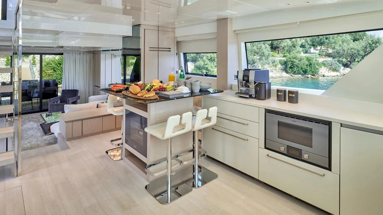The modern galley is well-equipped with sleek appliances and a spacious layout, offering a beautiful view through large windows. aboard SAHASA I Yacht for Sale