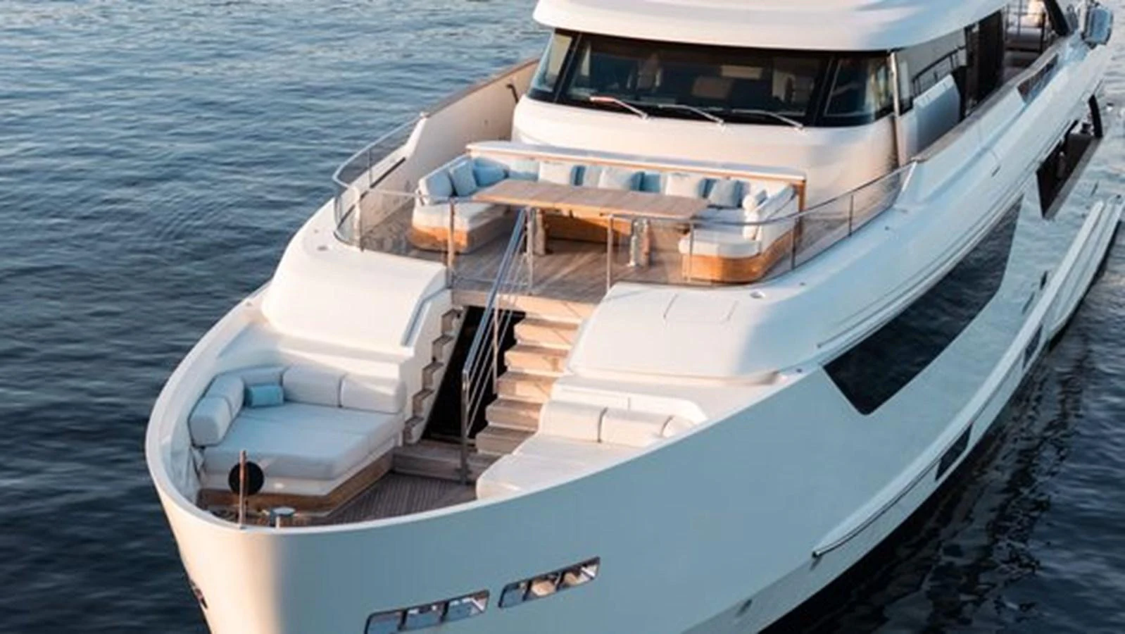 A luxurious yacht with spacious outdoor seating and elegant design cruising on calm waters. aboard 2022 SANLORENZO SD118 Yacht for Sale