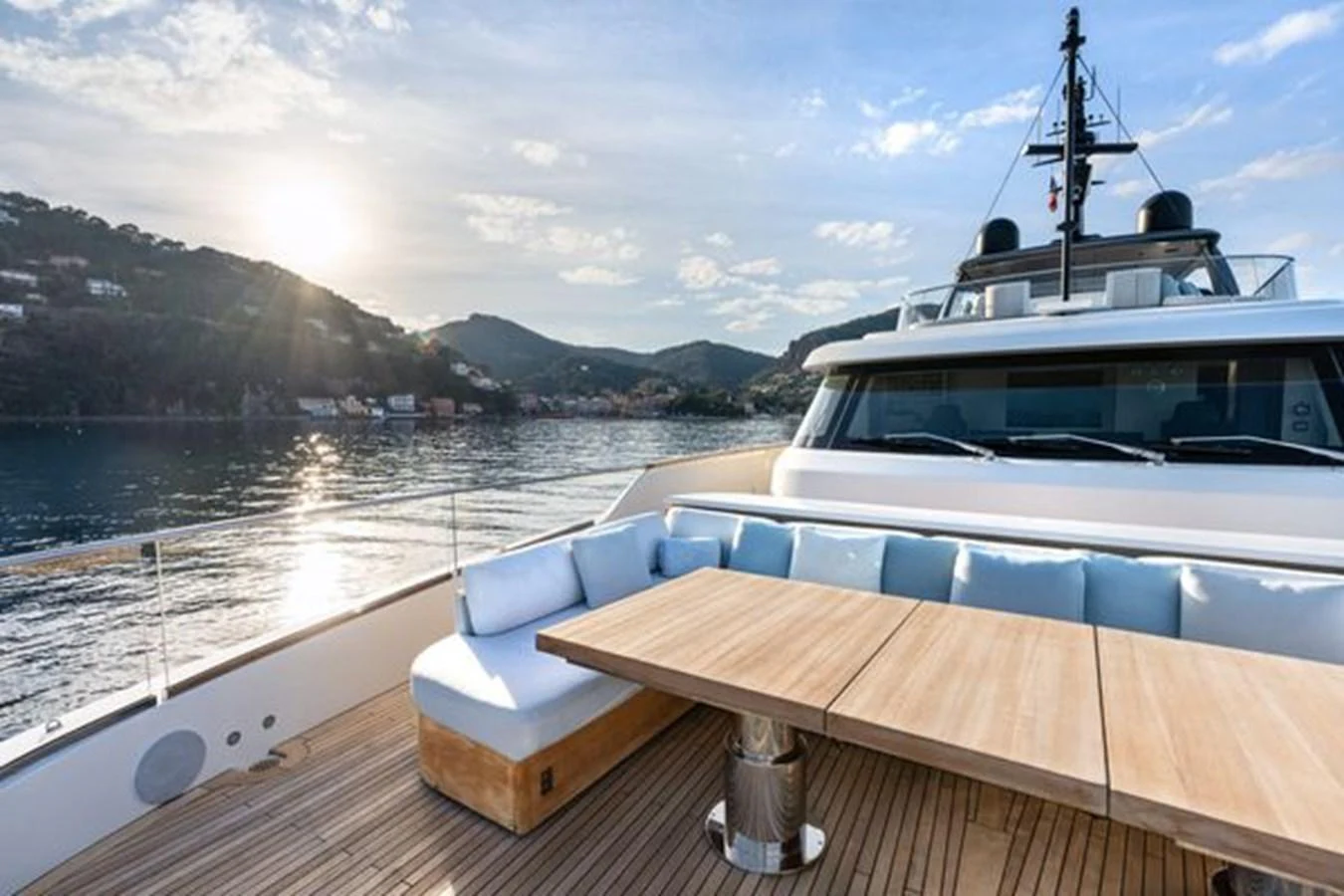 The yacht's aft deck features a spacious seating area with a wooden table, perfect for enjoying the scenic views. aboard 2022 SANLORENZO SD118 Yacht for Sale