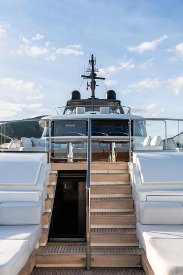 The yacht's exterior showcases a luxurious staircase leading up to a spacious deck area under a clear sky. aboard 2022 SANLORENZO SD118 Yacht for Sale