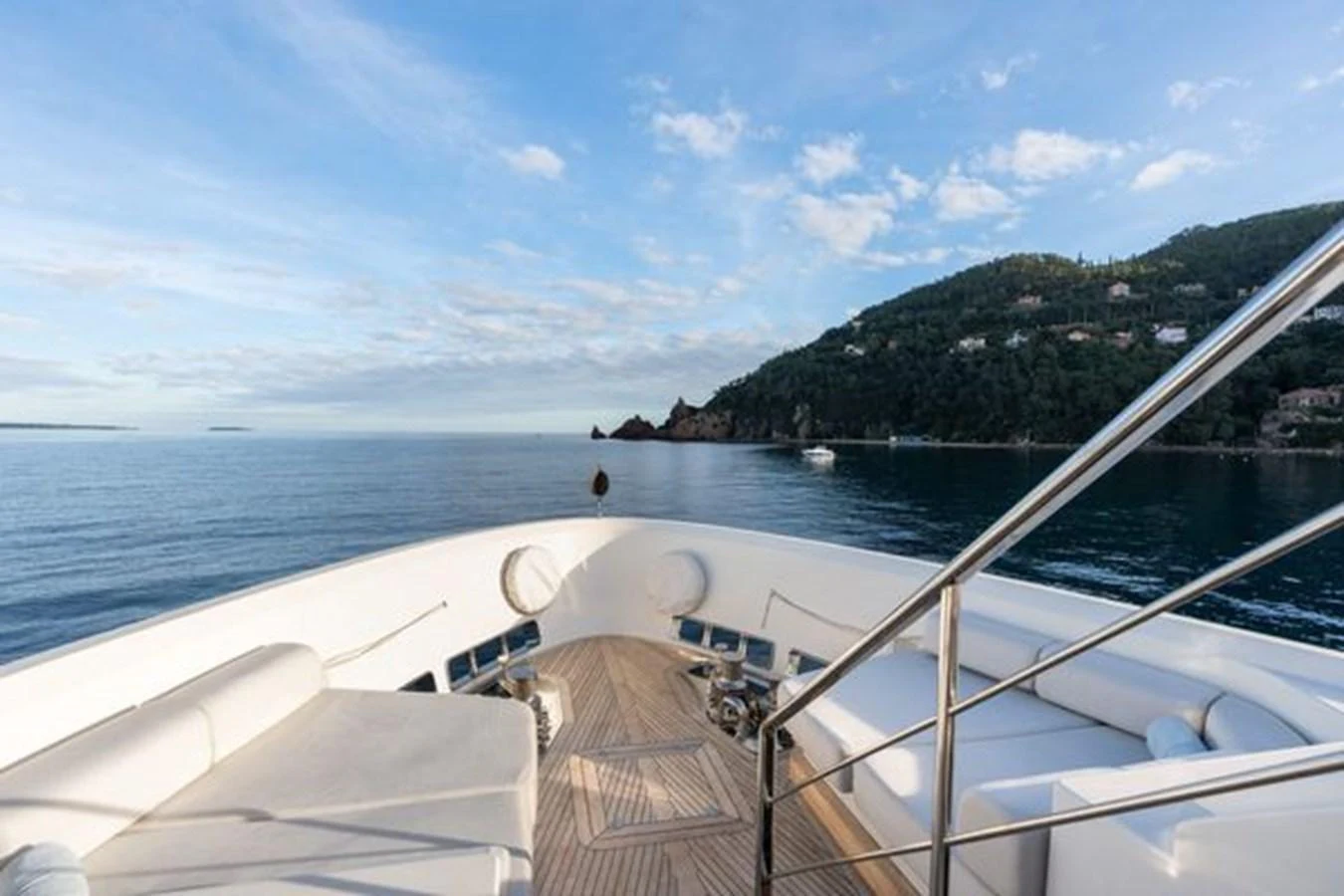 The yacht's bow offers a serene seating area with stunning ocean views and a glimpse of the coastline. aboard 2022 SANLORENZO SD118 Yacht for Sale