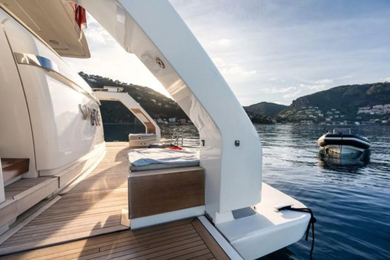 The yacht's aft deck offers a serene view of the surrounding waters and nearby hills. aboard 2022 SANLORENZO SD118 Yacht for Sale