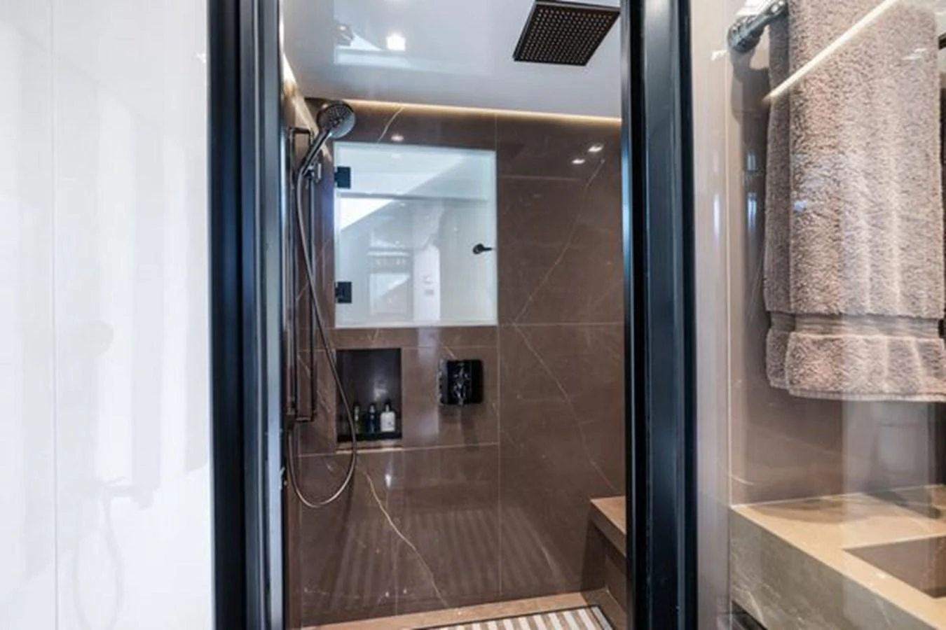 A luxurious yacht bathroom featuring a spacious shower with modern fixtures and elegant design. aboard 2022 SANLORENZO SD118 Yacht for Sale