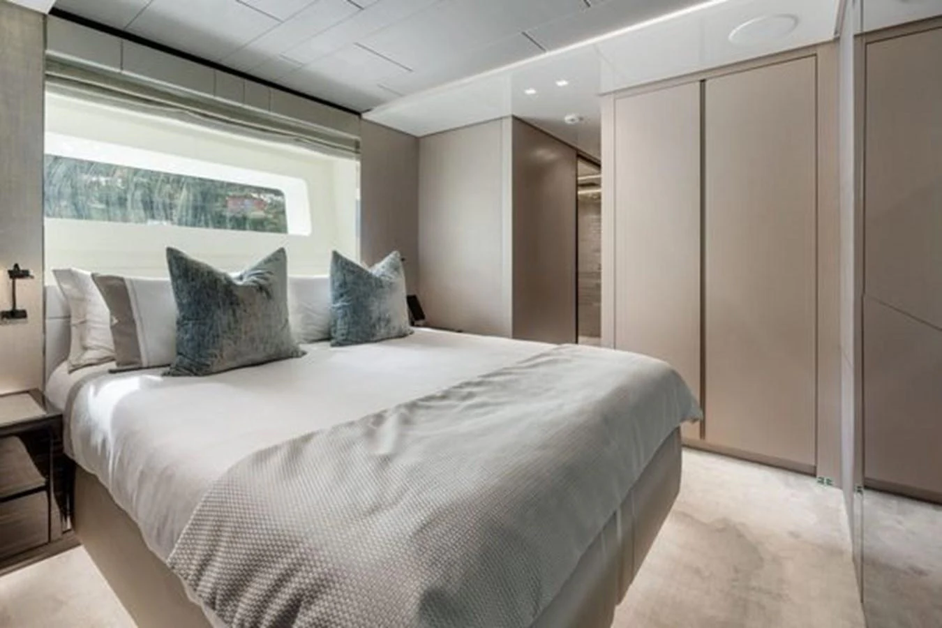 The stateroom features a plush bed with elegant bedding and ample natural light from a large window. aboard 2022 SANLORENZO SD118 Yacht for Sale