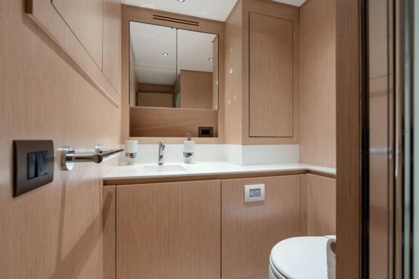 The yacht's bathroom features sleek wood paneling and modern fixtures. aboard 2022 SANLORENZO SD118 Yacht for Sale