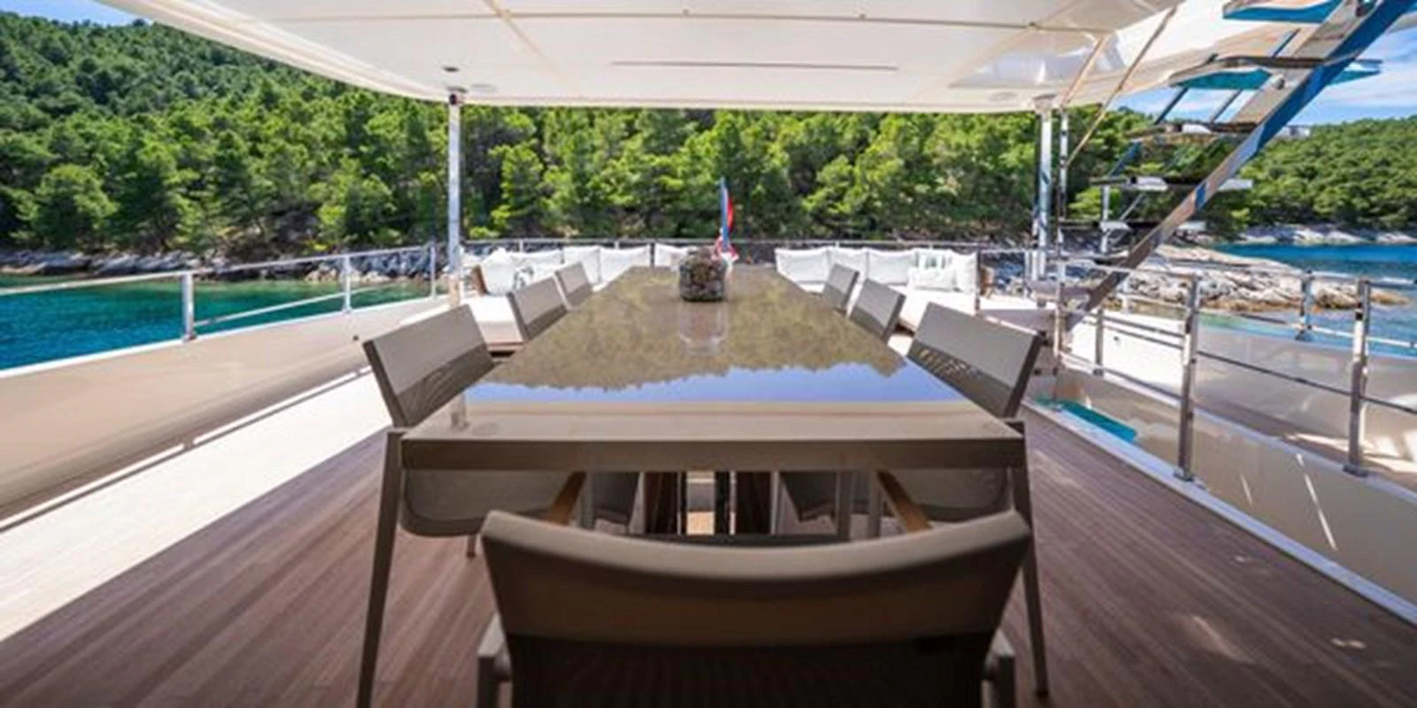 a deck with a pool and a deck with chairs and trees aboard SK Yacht for Sale