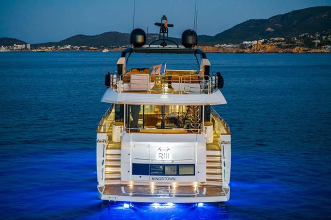 The yacht is beautifully illuminated at dusk, showcasing its elegant aft deck and inviting ambiance. aboard 2015 SUNSEEKER 28M RIII Yacht for Sale