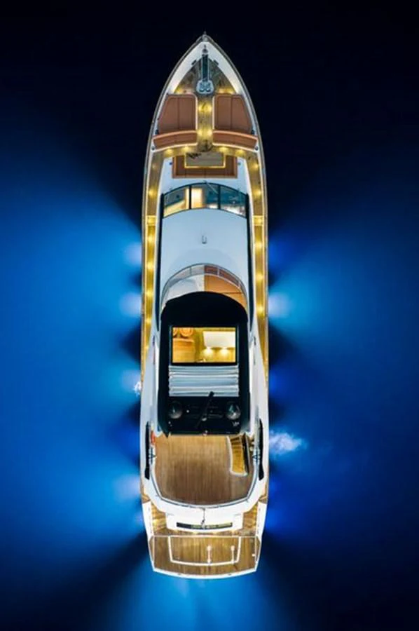 A stunning aerial view of a yacht illuminated against the dark water, showcasing its elegant design and lighting. aboard 2015 SUNSEEKER 28M RIII Yacht for Sale