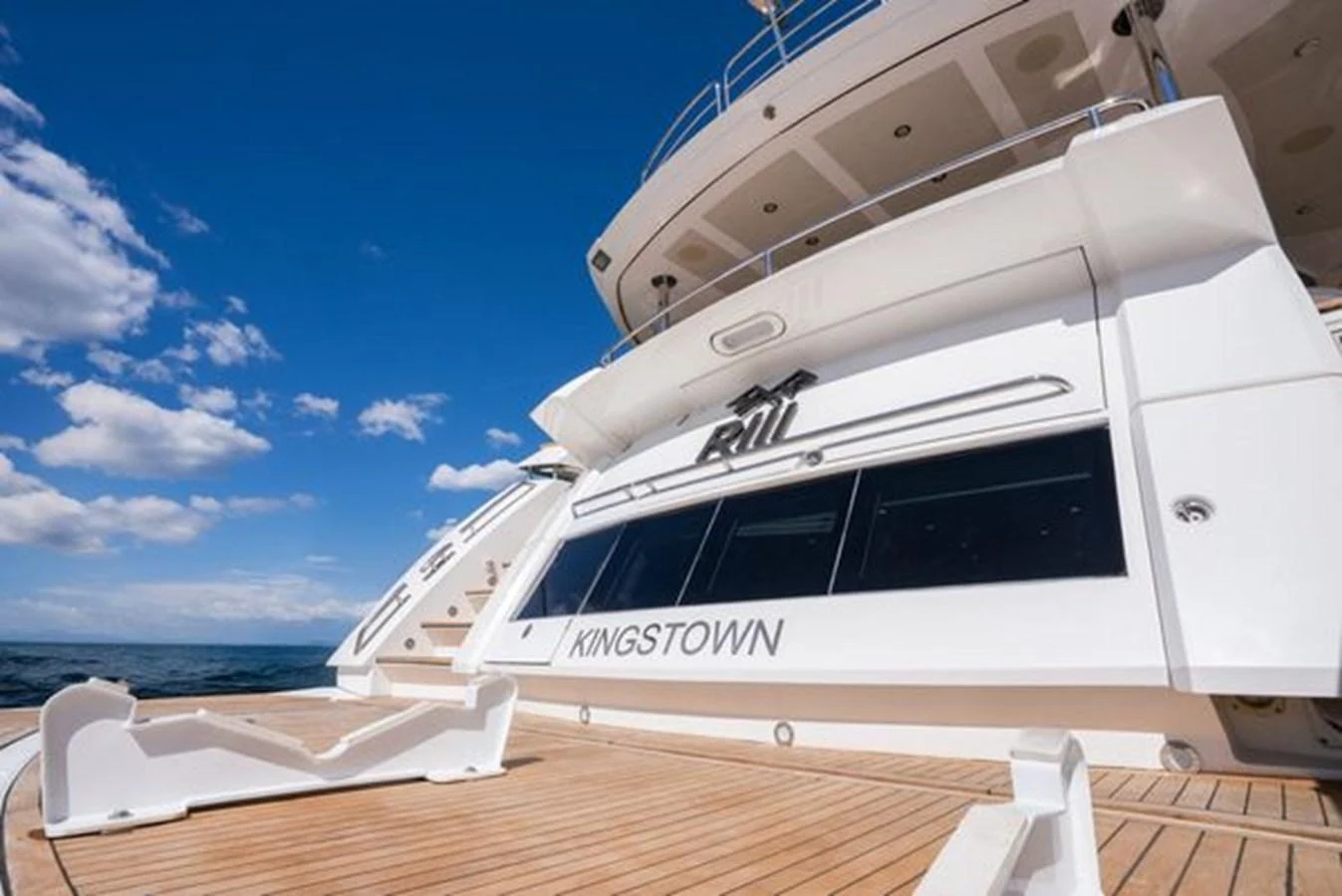 The yacht's aft deck showcases a spacious and inviting area with elegant wooden flooring and sleek design elements. aboard 2015 SUNSEEKER 28M RIII Yacht for Sale