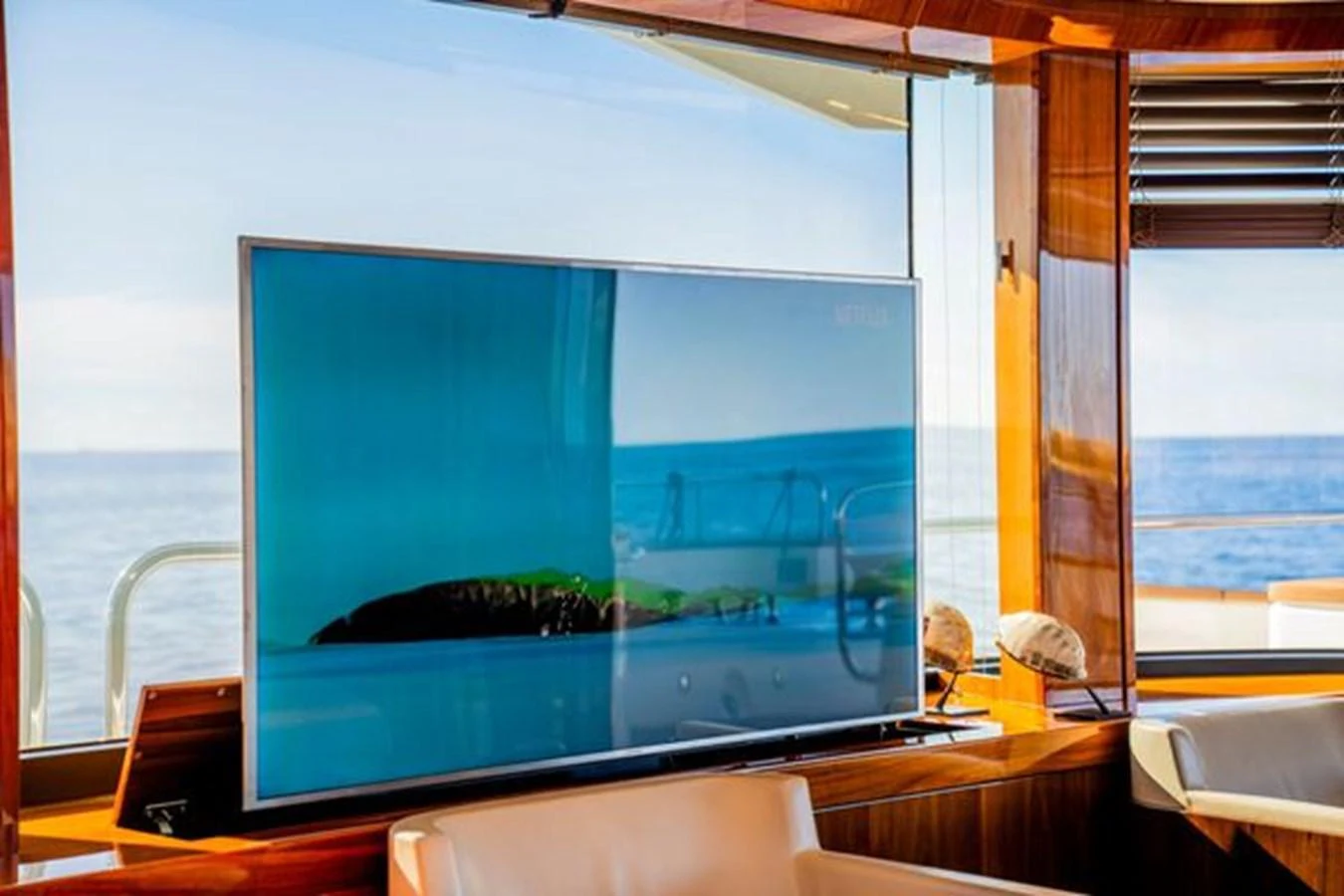 The yacht's interior features a large flat-screen TV with a scenic ocean view through the windows. aboard 2015 SUNSEEKER 28M RIII Yacht for Sale