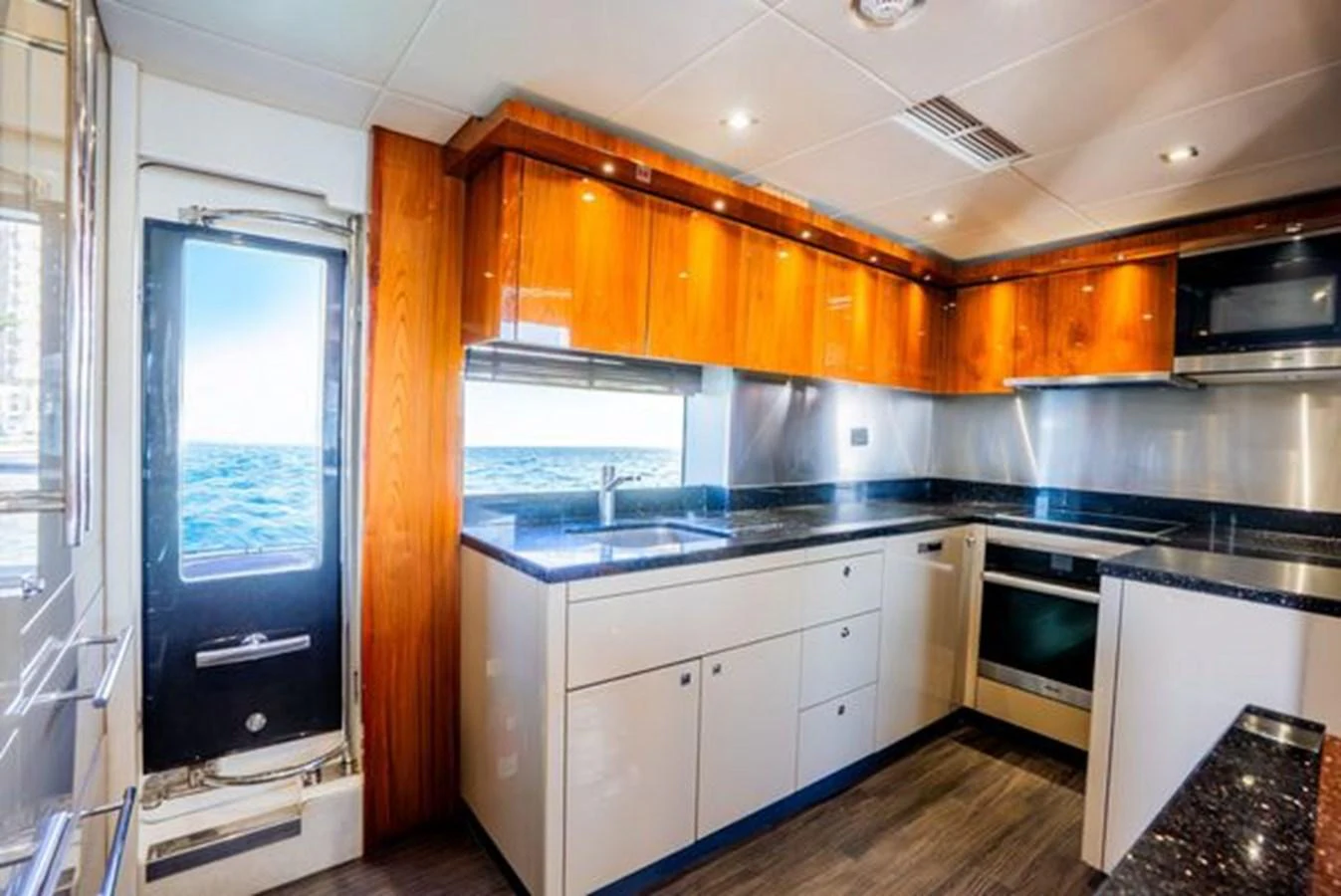 The galley features modern appliances and a sleek design with ample counter space and wooden cabinetry. aboard 2015 SUNSEEKER 28M RIII Yacht for Sale