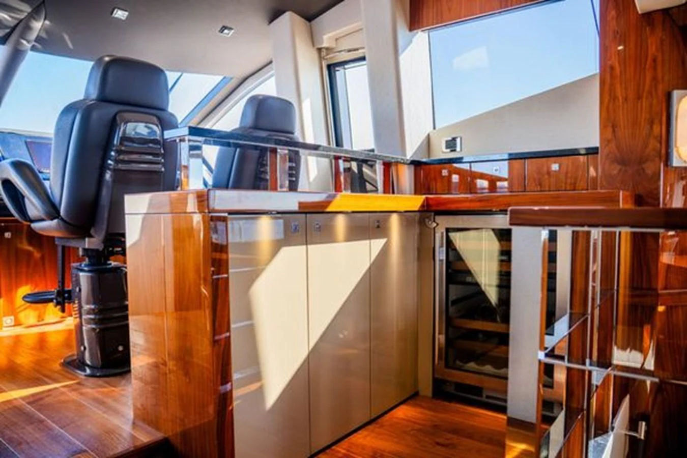 The helm station features luxurious wood finishes and modern seating with panoramic views. aboard 2015 SUNSEEKER 28M RIII Yacht for Sale