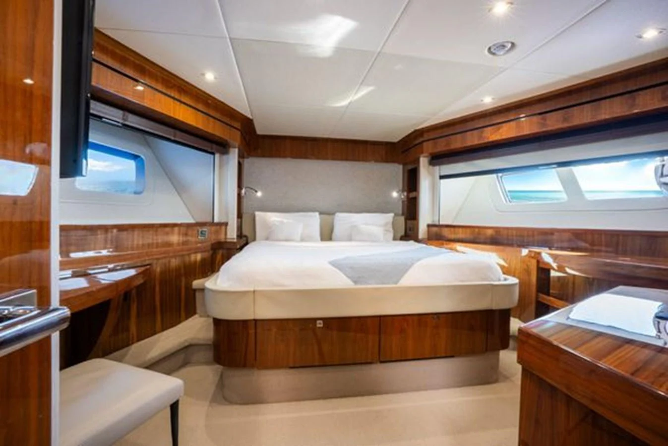 The master stateroom features a luxurious bed with ample natural light from large windows on both sides. aboard 2015 SUNSEEKER 28M RIII Yacht for Sale