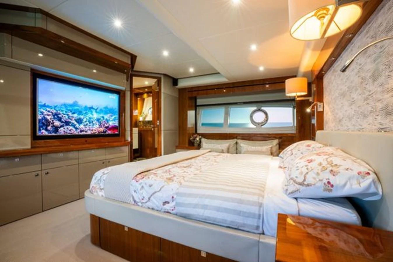 The master stateroom features a luxurious bed, elegant lighting, and a large TV for entertainment. aboard 2015 SUNSEEKER 28M RIII Yacht for Sale