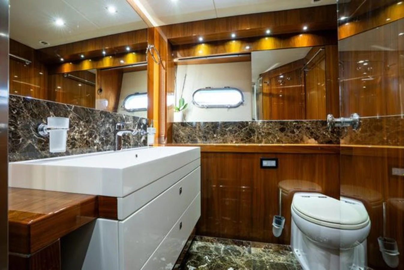 The yacht's bathroom features luxurious wood paneling, marble accents, and modern fixtures. aboard 2015 SUNSEEKER 28M RIII Yacht for Sale