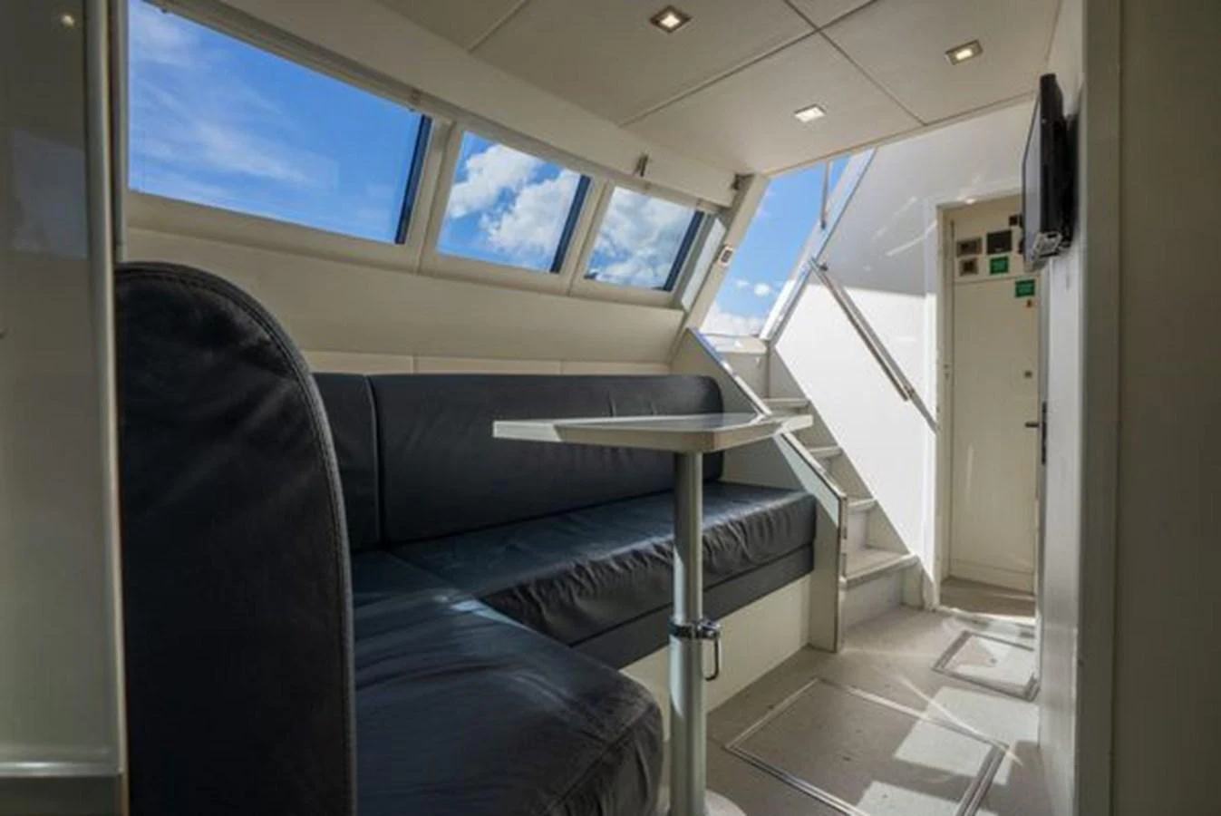 The yacht's interior features a cozy seating area with ample natural light from large windows. aboard 2015 SUNSEEKER 28M RIII Yacht for Sale
