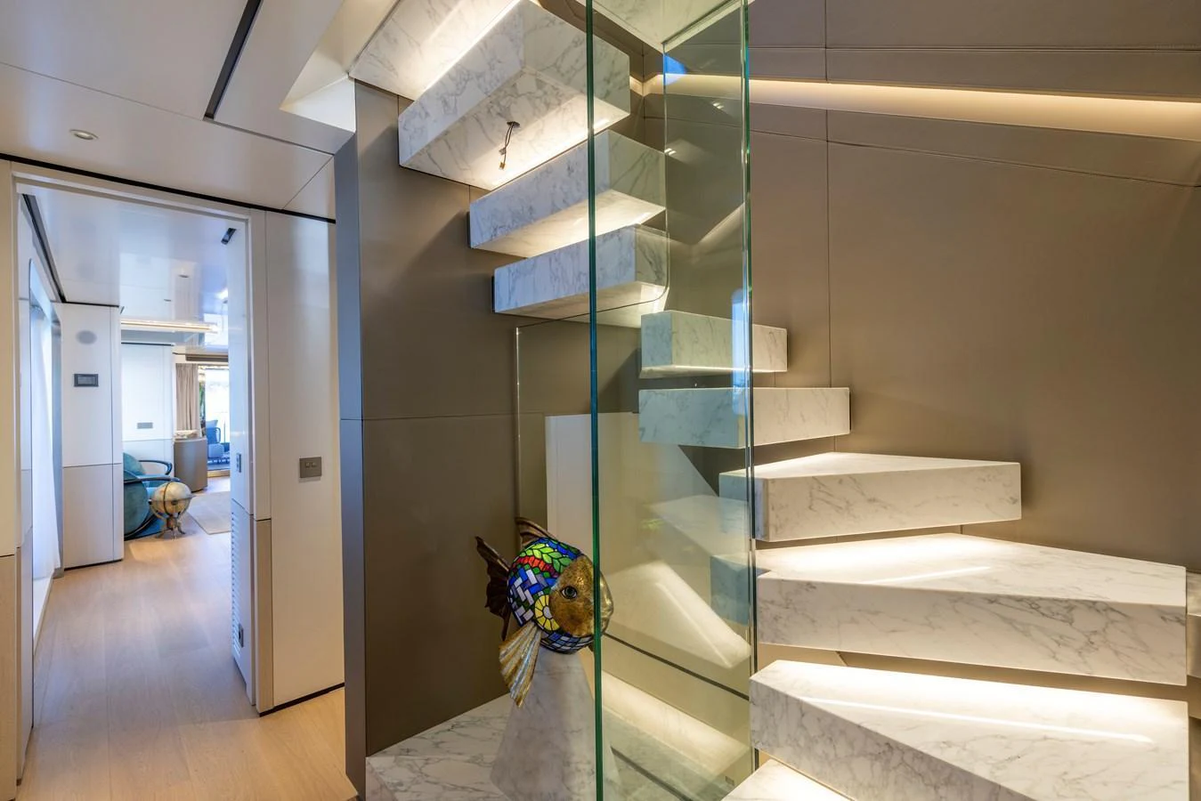 A modern interior staircase with marble steps and glass railing. aboard BEE EXPLORER YACHT Yacht for Sale