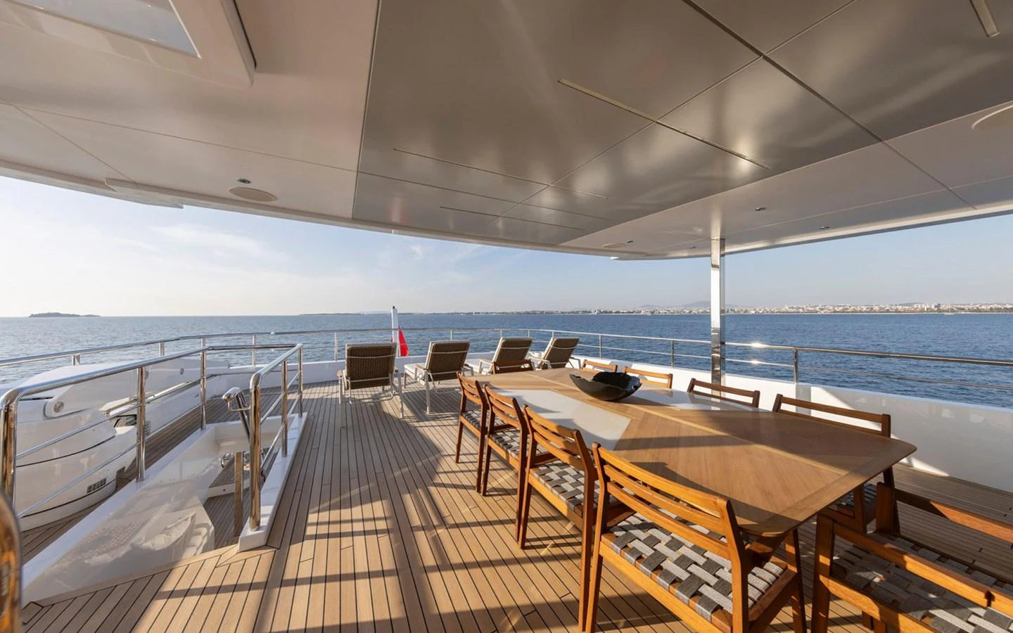 The aft deck features a spacious dining area with a large table and comfortable chairs, perfect for alfresco meals with a stunning sea view. aboard BEE EXPLORER YACHT Yacht for Sale